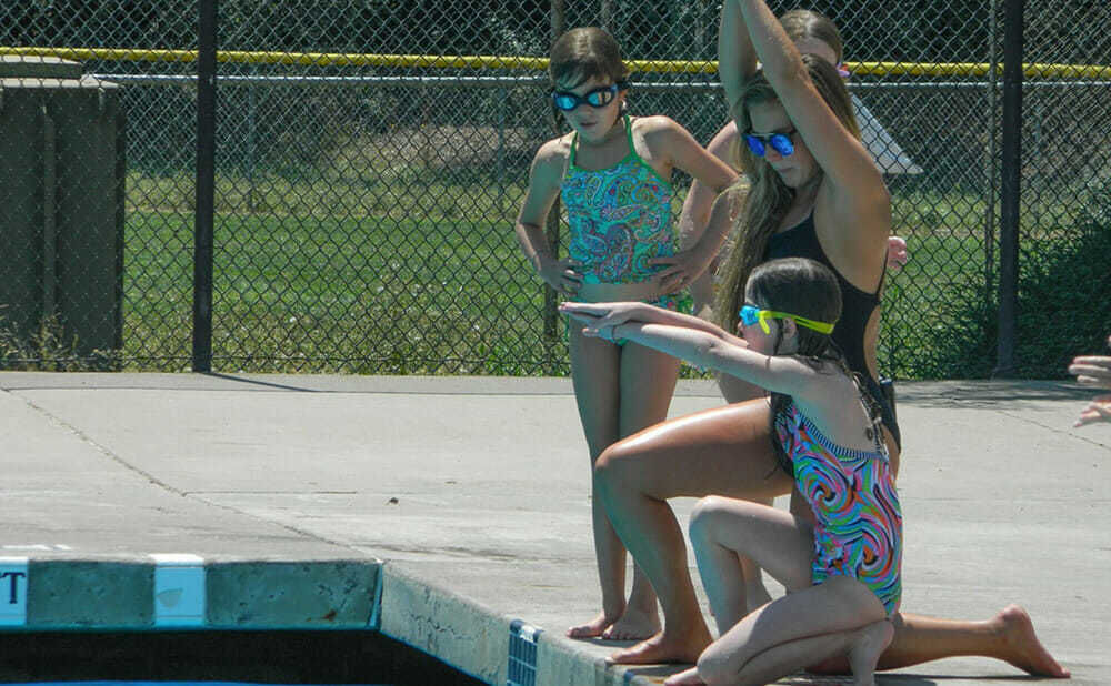 Swimming Counselor Leads Teen Campers in Diving Lesson