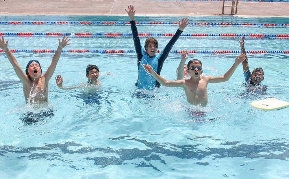 Young Boy Campers Practice Eggbeater Kicks in Pool During Swimming