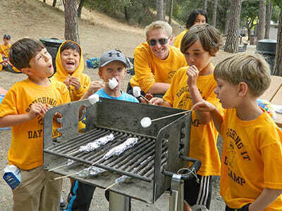 Young Boy Campers Roast Marshmallows over the Grill
