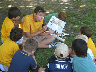 Young Boy Campers Hear a Story from a Picture Book