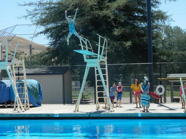 female camper ar roughing it day camp going off high dive 