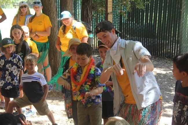 Counselor and campers celebrating Hawaiian dress up day, hula dancing. 