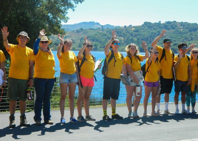 Counselors waving goodbye to campers and busses at the lafayette reservoir 