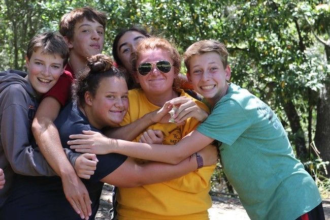 teen campers hugging counselor at roughing it day camp at the lafayette reservoir. 